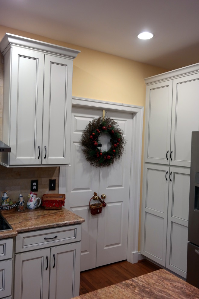 Imagen de cocina actual con armarios con paneles empotrados, puertas de armario blancas, encimera de granito, electrodomésticos de acero inoxidable y una isla