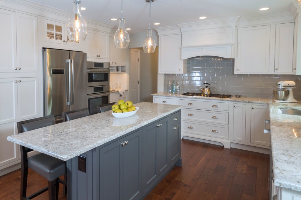 Example of a large transitional u-shaped medium tone wood floor and brown floor eat-in kitchen design in Philadelphia with an undermount sink, recessed-panel cabinets, white cabinets, granite countertops, gray backsplash, subway tile backsplash, stainless steel appliances and an island