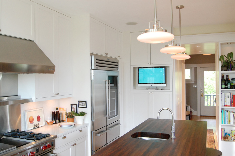Пример оригинального дизайна: кухня в классическом стиле с деревянной столешницей и телевизором