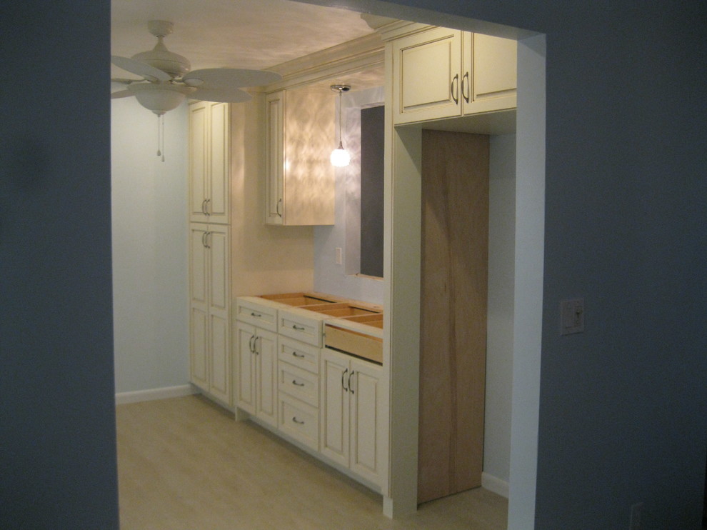 This is an example of a medium sized classic galley kitchen in Miami with raised-panel cabinets.