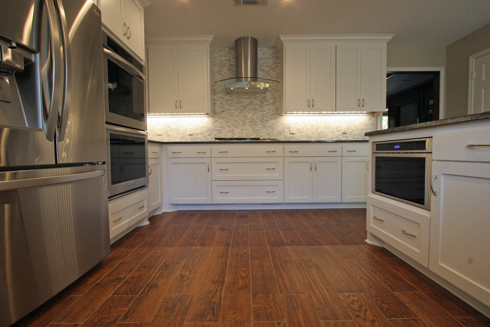 Esempio di una cucina moderna con ante in stile shaker, ante bianche, top in granito, pavimento marrone e top multicolore