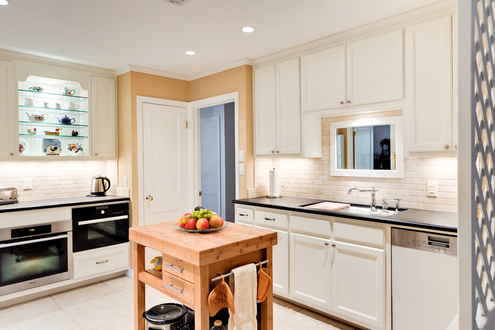На фото: отдельная кухня в классическом стиле с врезной мойкой, фасадами с утопленной филенкой, белыми фасадами, белым фартуком и фартуком из плитки кабанчик