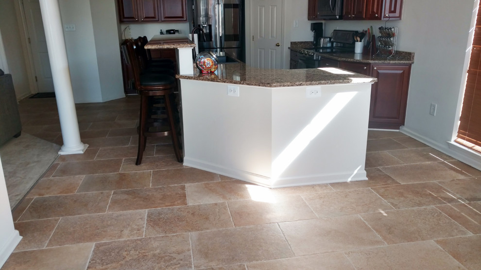 Eat-in kitchen - large transitional porcelain tile and beige floor eat-in kitchen idea with an undermount sink, raised-panel cabinets, black cabinets, quartz countertops and an island