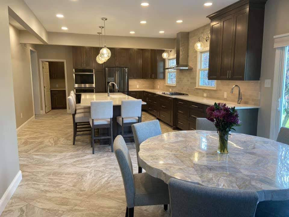 Wohnküche mit grauen Schränken, Quarzwerkstein-Arbeitsplatte, Keramikboden, Kücheninsel und weißer Arbeitsplatte in Philadelphia