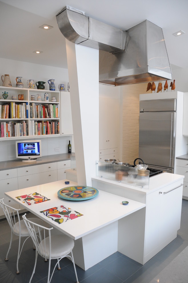 Cette photo montre une cuisine tendance avec un placard à porte plane et des portes de placard blanches.