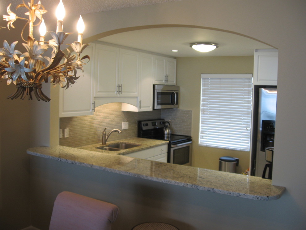 Exempel på ett avskilt, mellanstort modernt u-kök, med en undermonterad diskho, skåp i shakerstil, vita skåp, granitbänkskiva, flerfärgad stänkskydd, stänkskydd i glaskakel och rostfria vitvaror