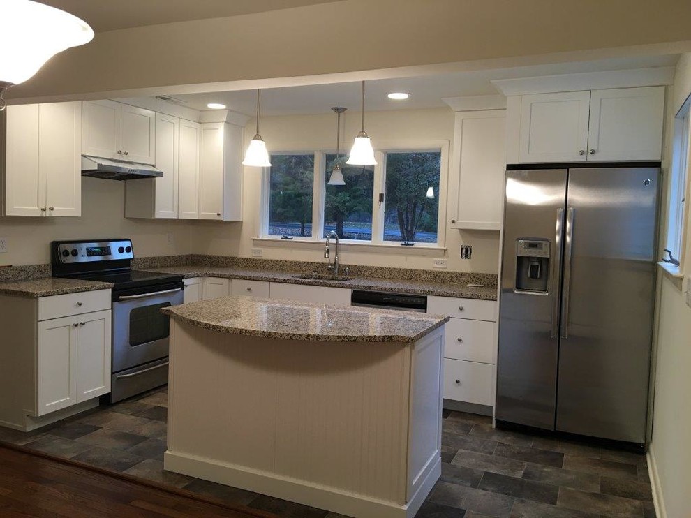 Kleine Moderne Küche mit Unterbauwaschbecken, weißen Schränken, Granit-Arbeitsplatte, Küchengeräten aus Edelstahl, braunem Holzboden und Kücheninsel in Philadelphia