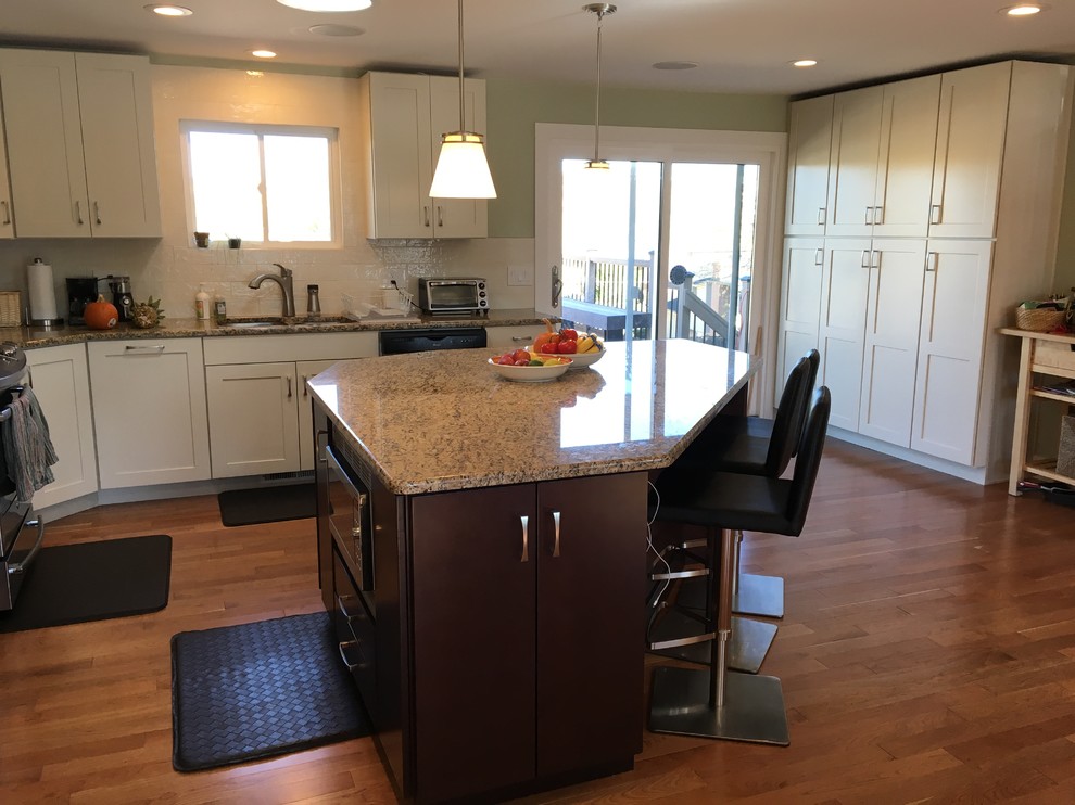Eat-in kitchen - traditional galley eat-in kitchen idea in Denver with recessed-panel cabinets, white cabinets, granite countertops, white backsplash and an island