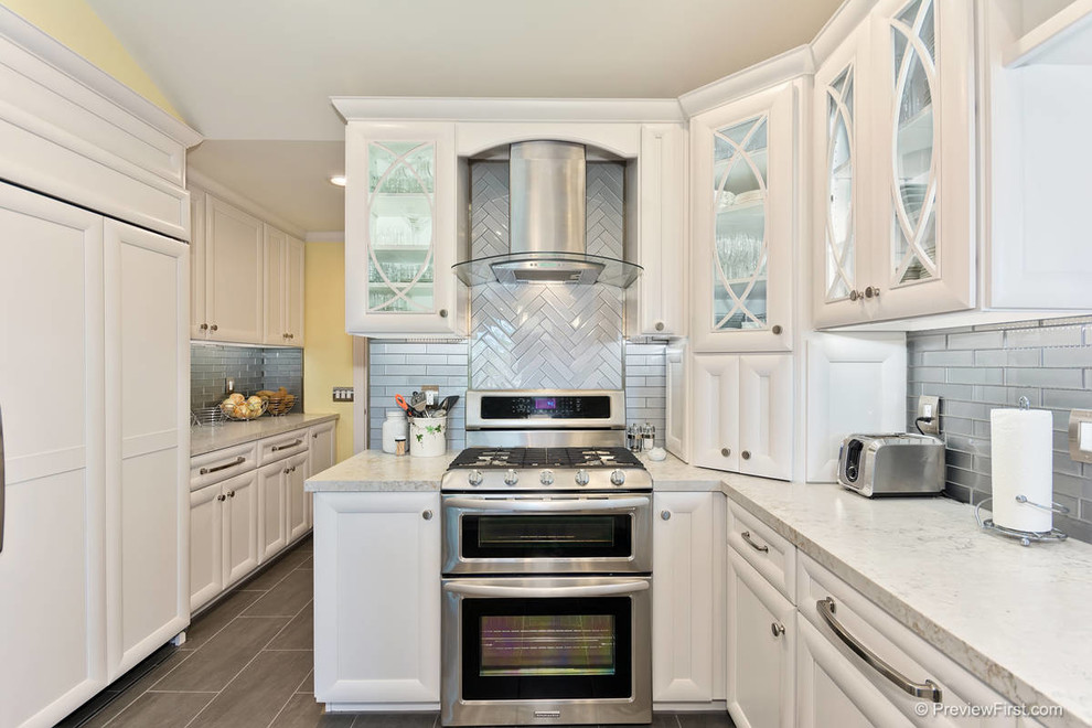 Exempel på ett mellanstort klassiskt kök, med en undermonterad diskho, luckor med infälld panel, vita skåp, bänkskiva i kvartsit, grått stänkskydd, stänkskydd i glaskakel, rostfria vitvaror, klinkergolv i keramik och en halv köksö