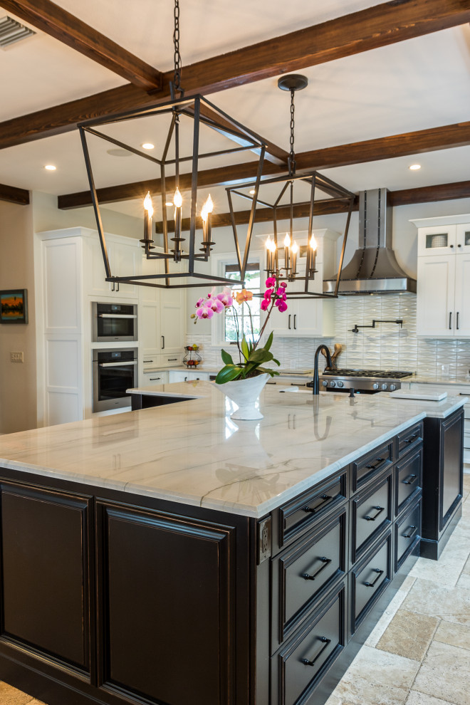 Inspiration for a huge timeless l-shaped travertine floor and beige floor kitchen remodel in Orlando with a farmhouse sink, raised-panel cabinets, black cabinets, quartzite countertops, white backsplash, porcelain backsplash, stainless steel appliances, an island and white countertops