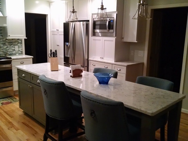 ニューヨークにある中くらいなトランジショナルスタイルのおしゃれなキッチン (シングルシンク、シェーカースタイル扉のキャビネット、白いキャビネット、クオーツストーンカウンター、青いキッチンパネル、シルバーの調理設備、無垢フローリング) の写真