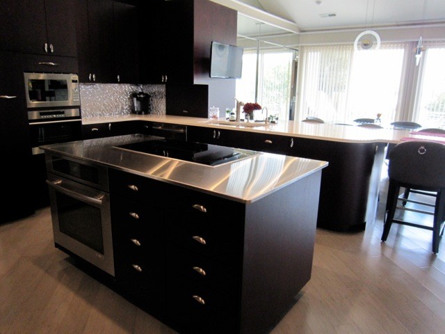 Example of a mid-sized minimalist u-shaped light wood floor eat-in kitchen design in Other with an undermount sink, flat-panel cabinets, dark wood cabinets, marble countertops, metallic backsplash, glass sheet backsplash, stainless steel appliances and an island