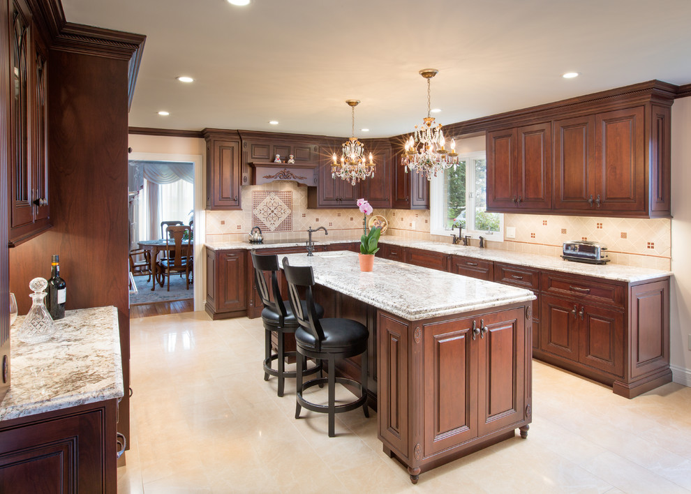 Example of a large classic u-shaped marble floor kitchen design in Columbus with an undermount sink, beaded inset cabinets, medium tone wood cabinets, granite countertops, beige backsplash, stone tile backsplash, stainless steel appliances and an island