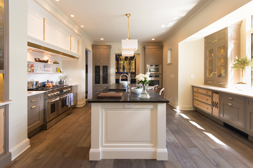 Example of a large transitional galley medium tone wood floor and brown floor open concept kitchen design in Chicago with an undermount sink, white cabinets, onyx countertops, white backsplash, stone tile backsplash, stainless steel appliances, an island and raised-panel cabinets