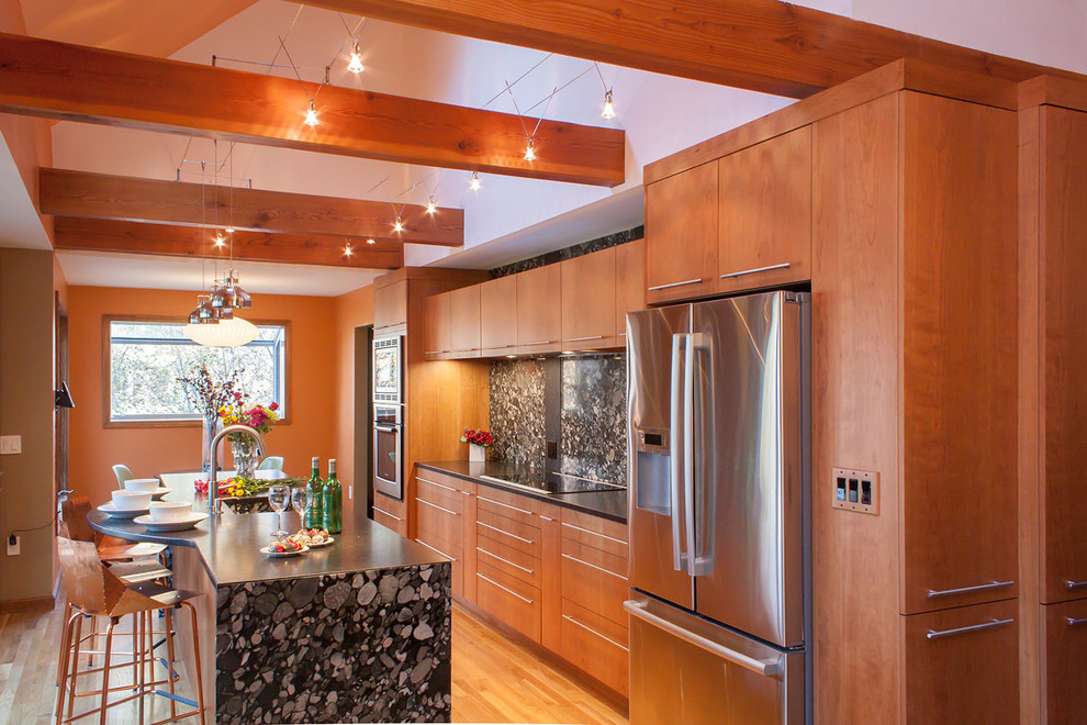 Einzeilige Moderne Wohnküche mit Landhausspüle, flächenbündigen Schrankfronten, hellbraunen Holzschränken, Granit-Arbeitsplatte, Küchenrückwand in Schwarz und Küchengeräten aus Edelstahl in Boston