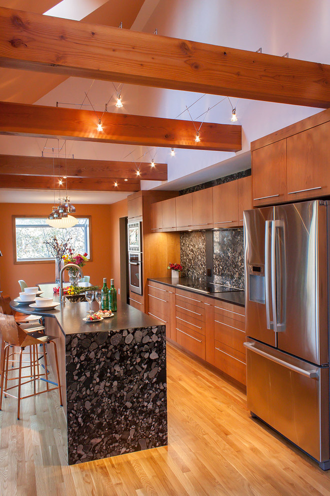 Foto på ett funkis linjärt kök och matrum, med en rustik diskho, släta luckor, skåp i mellenmörkt trä, granitbänkskiva, svart stänkskydd och rostfria vitvaror