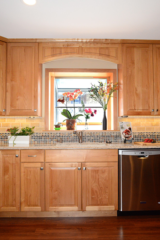 This is an example of a medium sized traditional l-shaped enclosed kitchen in Chicago with a submerged sink, recessed-panel cabinets, medium wood cabinets, engineered stone countertops, grey splashback, stone tiled splashback, stainless steel appliances, medium hardwood flooring and no island.