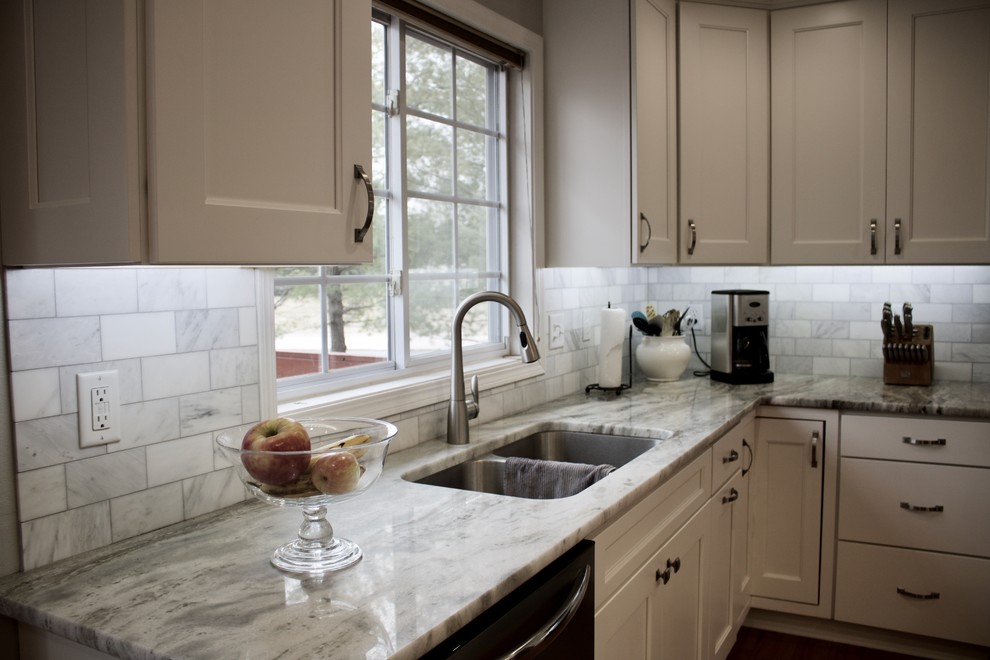 Klassisk inredning av ett flerfärgad flerfärgat kök, med en undermonterad diskho, skåp i shakerstil, vita skåp, granitbänkskiva, vitt stänkskydd, stänkskydd i marmor, rostfria vitvaror, mörkt trägolv och brunt golv