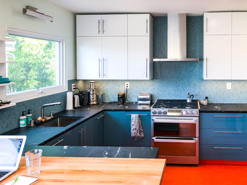 Immagine di una cucina minimalista di medie dimensioni con ante lisce, ante bianche, paraspruzzi blu, elettrodomestici in acciaio inossidabile, penisola, pavimento arancione, lavello da incasso, top in granito, paraspruzzi con piastrelle a mosaico, top nero e pavimento in vinile