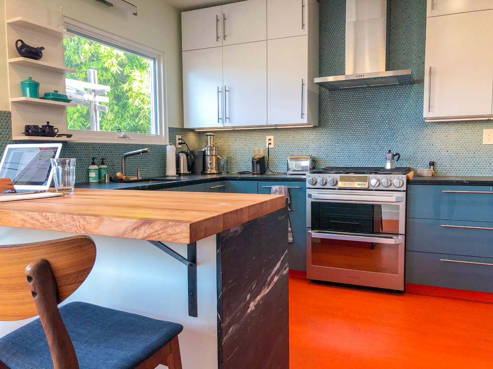 Idéer för att renovera ett mellanstort funkis svart svart kök, med en undermonterad diskho, släta luckor, vita skåp, blått stänkskydd, rostfria vitvaror, en halv köksö, orange golv, granitbänkskiva, stänkskydd i mosaik och vinylgolv