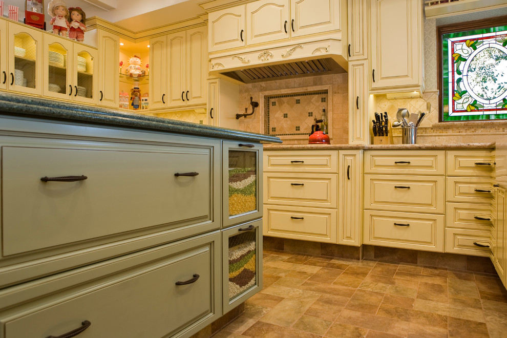 Bild på ett avskilt, stort vintage u-kök, med en rustik diskho, luckor med upphöjd panel, gula skåp, granitbänkskiva, beige stänkskydd, stänkskydd i stenkakel, integrerade vitvaror, klinkergolv i porslin och en köksö