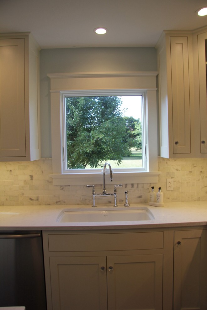 Example of a mid-sized classic l-shaped dark wood floor eat-in kitchen design in Detroit with an undermount sink, shaker cabinets, turquoise cabinets, solid surface countertops, white backsplash, subway tile backsplash, stainless steel appliances and an island