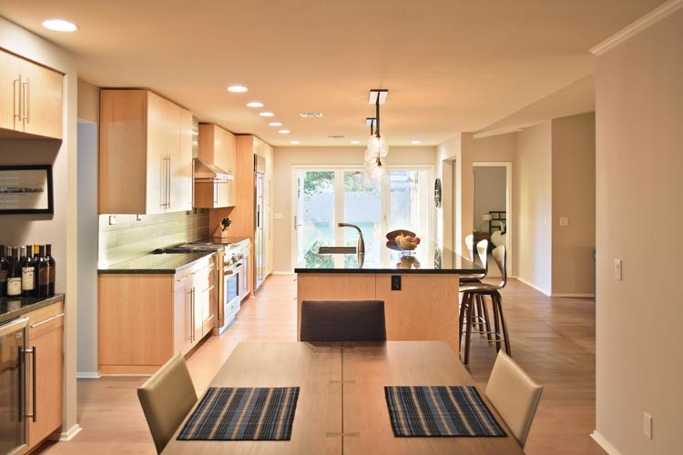 This is an example of a medium sized contemporary single-wall open plan kitchen in San Francisco with a double-bowl sink, flat-panel cabinets, light wood cabinets, granite worktops, grey splashback, ceramic splashback, stainless steel appliances, light hardwood flooring and an island.