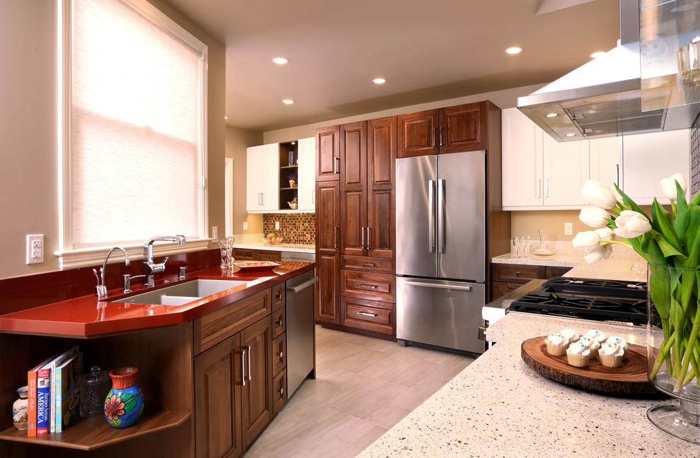 Photo of a medium sized contemporary l-shaped kitchen/diner in San Francisco with a double-bowl sink, raised-panel cabinets, medium wood cabinets, composite countertops, stainless steel appliances, porcelain flooring, a breakfast bar and red worktops.