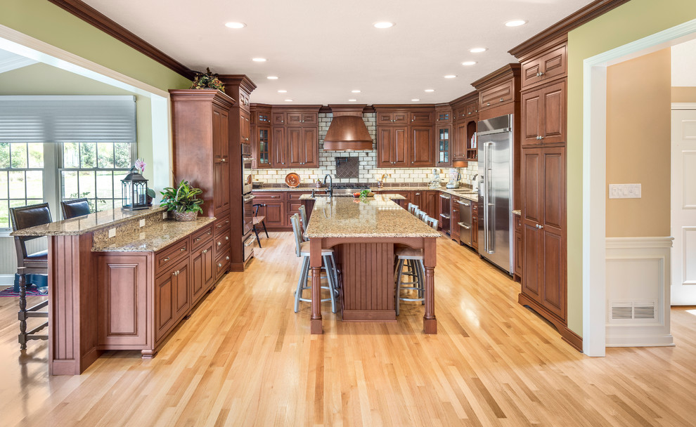 Inspiration for a large timeless galley light wood floor and beige floor eat-in kitchen remodel in Other with a double-bowl sink, raised-panel cabinets, medium tone wood cabinets, granite countertops, beige backsplash, ceramic backsplash, stainless steel appliances, an island and beige countertops