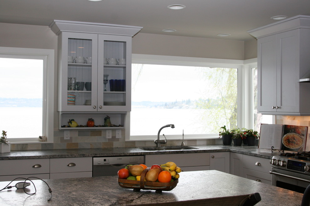 Exempel på ett stort modernt kök, med en rustik diskho, luckor med infälld panel, vita skåp, granitbänkskiva, beige stänkskydd, stänkskydd i tunnelbanekakel, rostfria vitvaror, mellanmörkt trägolv och en köksö