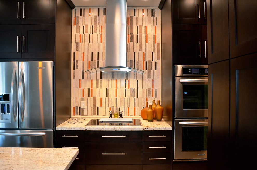 Moderne Küche mit flächenbündigen Schrankfronten, dunklen Holzschränken, Granit-Arbeitsplatte, Küchenrückwand in Orange, Rückwand aus Mosaikfliesen, Küchengeräten aus Edelstahl und Kücheninsel in Miami