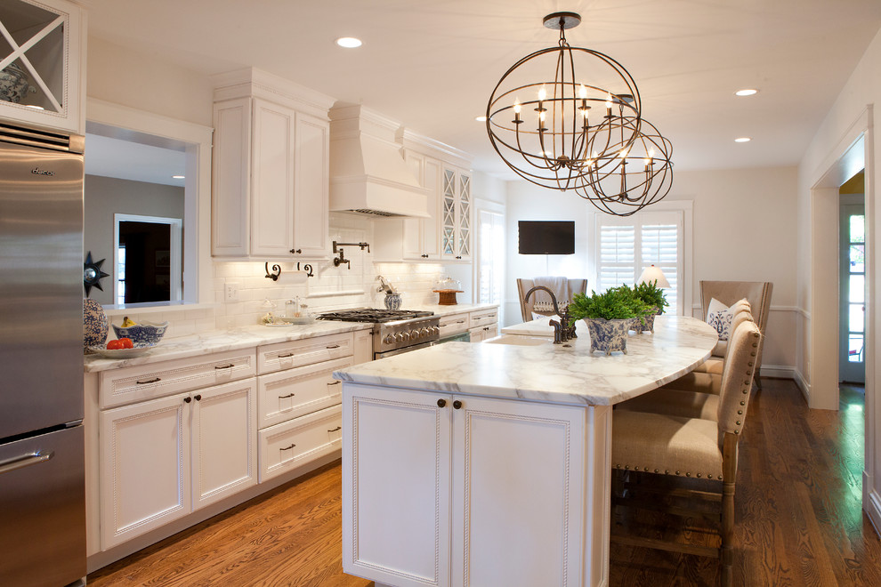 Exempel på ett stort klassiskt grå linjärt grått kök med öppen planlösning, med en rustik diskho, luckor med profilerade fronter, vita skåp, vitt stänkskydd, stänkskydd i tunnelbanekakel, rostfria vitvaror, mellanmörkt trägolv, en köksö, marmorbänkskiva och brunt golv