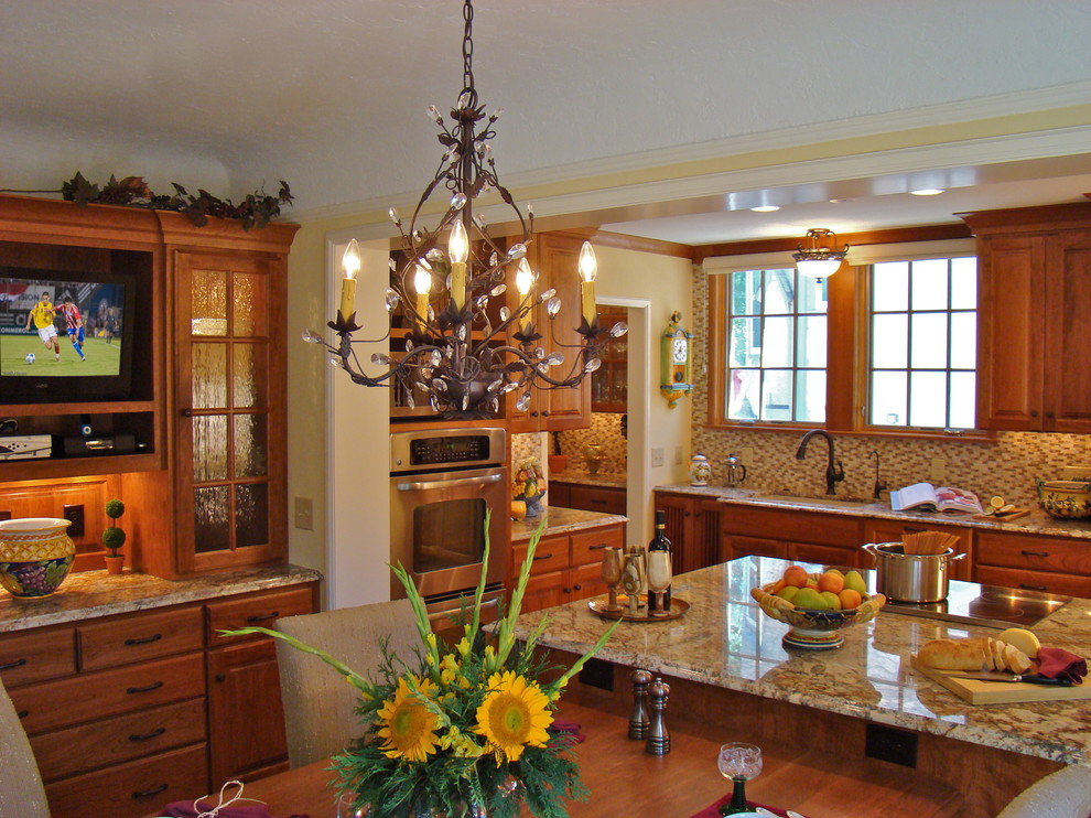 Пример оригинального дизайна: п-образная кухня в классическом стиле с обеденным столом, врезной мойкой, коричневыми фасадами, гранитной столешницей, разноцветным фартуком и техникой из нержавеющей стали