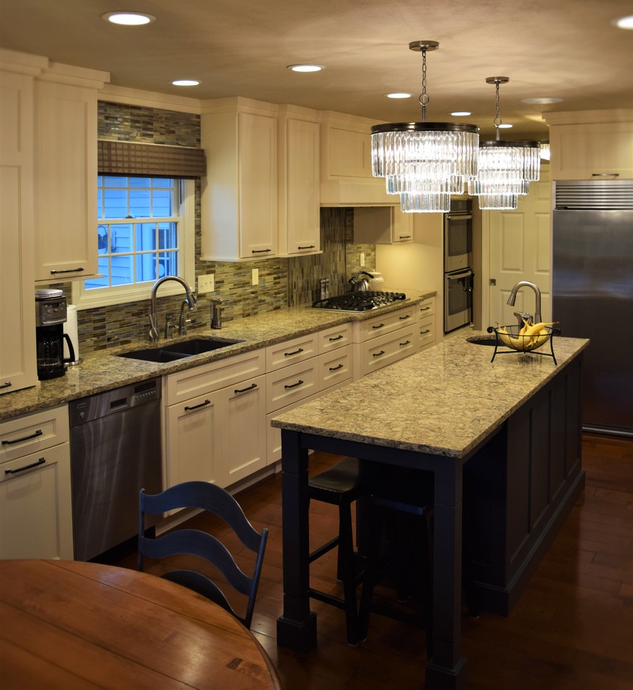 Foto på ett mellanstort vintage linjärt kök och matrum, med en undermonterad diskho, luckor med infälld panel, vita skåp, bänkskiva i kvartsit, flerfärgad stänkskydd, stänkskydd i mosaik, rostfria vitvaror, mellanmörkt trägolv och en köksö