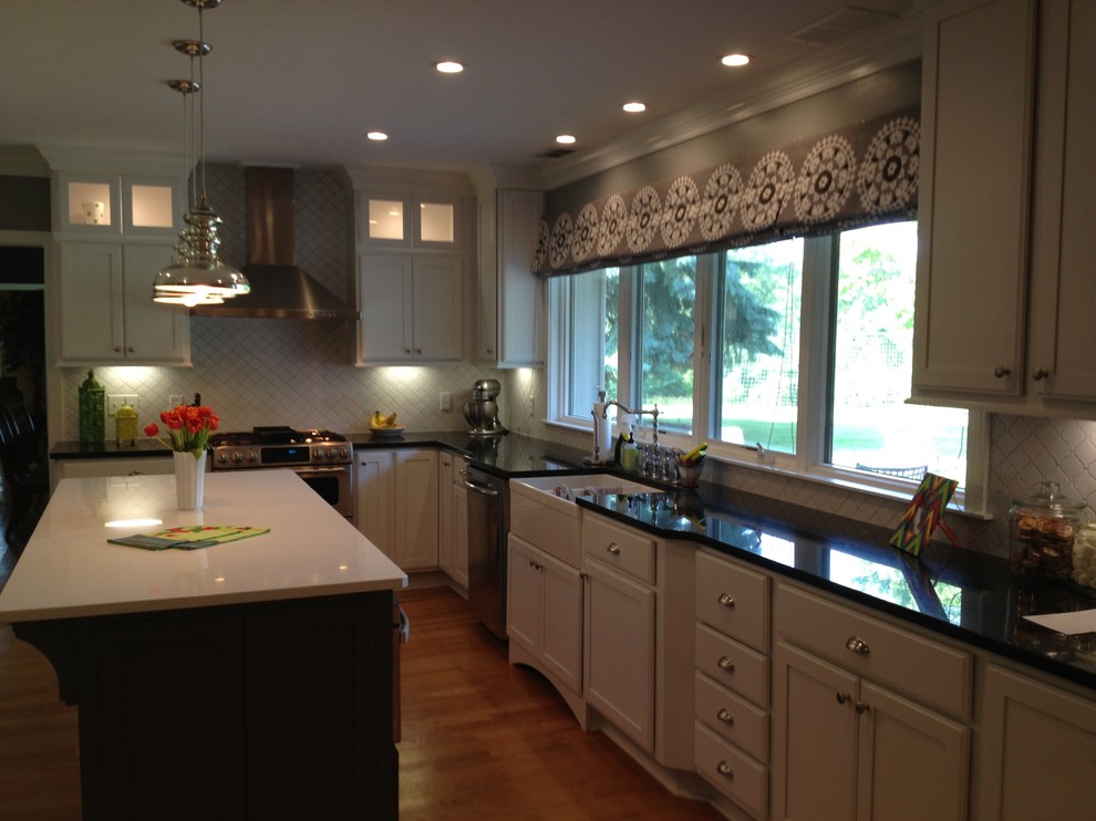 Exempel på ett avskilt, stort klassiskt u-kök, med en rustik diskho, släta luckor, grå skåp, granitbänkskiva, grått stänkskydd, stänkskydd i mosaik, rostfria vitvaror, mellanmörkt trägolv och en köksö