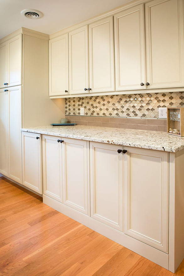 Exempel på ett stort klassiskt linjärt kök med öppen planlösning, med en undermonterad diskho, luckor med profilerade fronter, vita skåp, granitbänkskiva, flerfärgad stänkskydd, rostfria vitvaror, mellanmörkt trägolv och en köksö