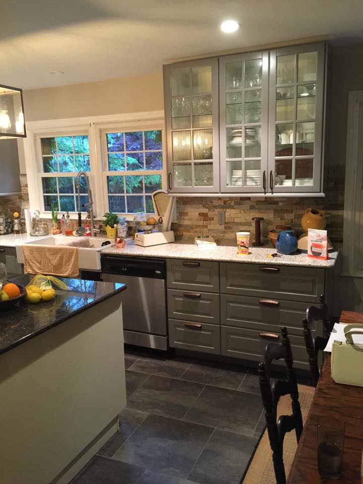 Example of a large mid-century modern l-shaped cement tile floor eat-in kitchen design in Indianapolis with a farmhouse sink, raised-panel cabinets, gray cabinets, granite countertops, beige backsplash, brick backsplash, stainless steel appliances and an island