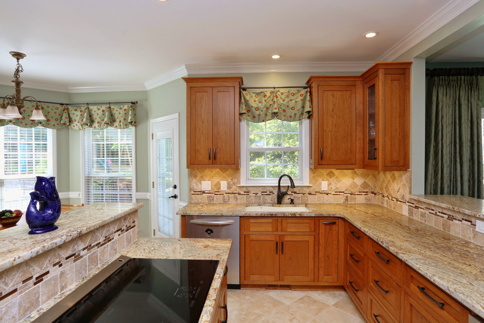 Example of a mid-sized classic u-shaped travertine floor and beige floor open concept kitchen design in Raleigh with an undermount sink, shaker cabinets, medium tone wood cabinets, granite countertops, beige backsplash, stone tile backsplash, stainless steel appliances, an island and multicolored countertops