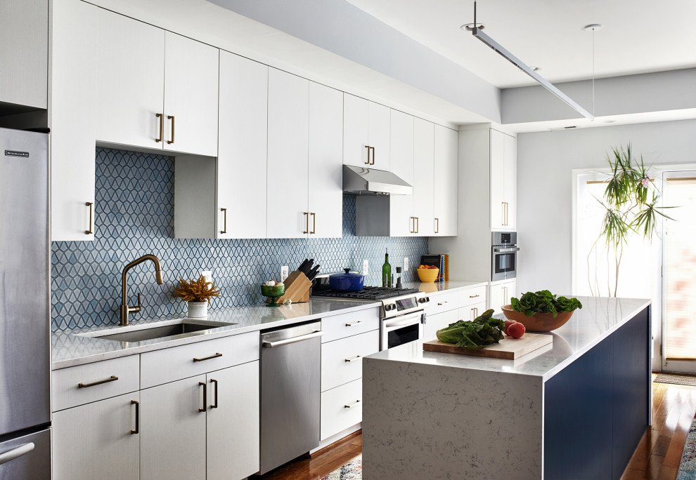 Exempel på ett mellanstort modernt vit vitt kök, med vita skåp, blått stänkskydd, rostfria vitvaror, mellanmörkt trägolv och en köksö