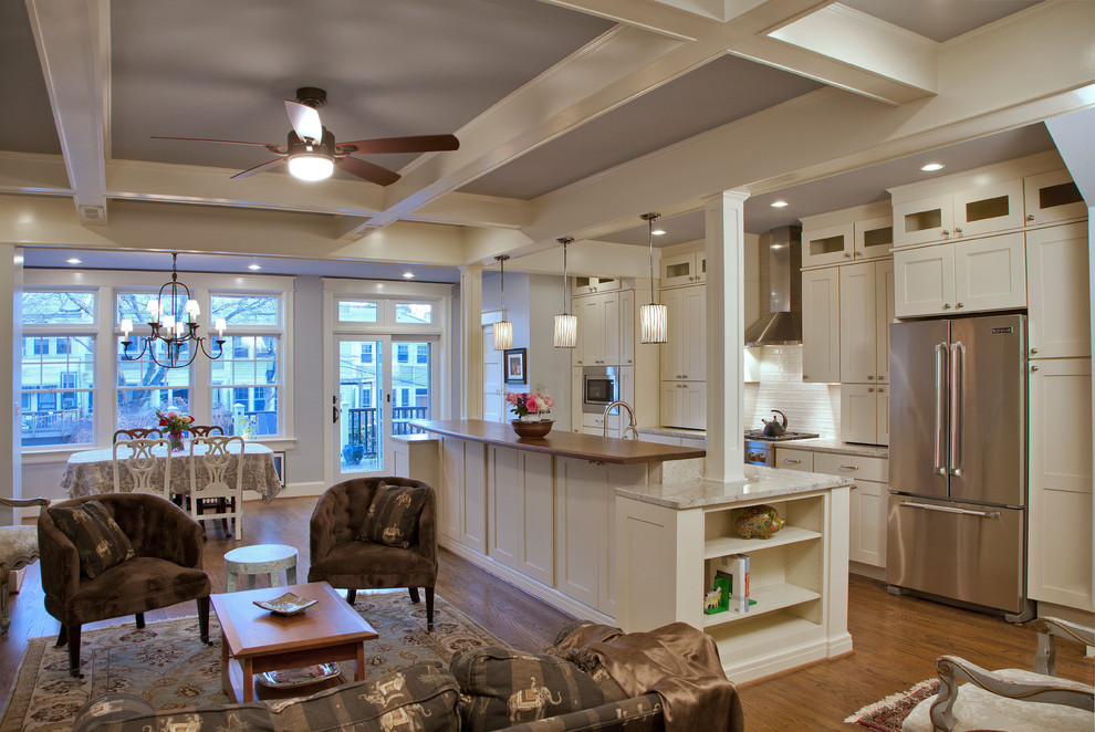 Bild på ett stort vintage linjärt kök med öppen planlösning, med en undermonterad diskho, skåp i shakerstil, vita skåp, granitbänkskiva, vitt stänkskydd, stänkskydd i keramik, rostfria vitvaror, mörkt trägolv, en köksö och brunt golv