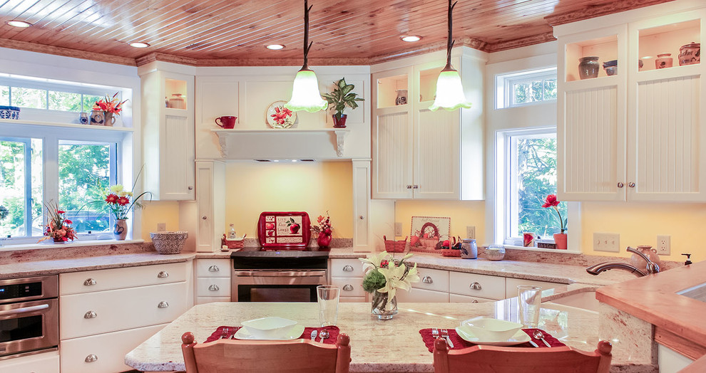 This is an example of a traditional u-shaped kitchen/diner in Boston with a submerged sink, recessed-panel cabinets, yellow cabinets, granite worktops and stainless steel appliances.