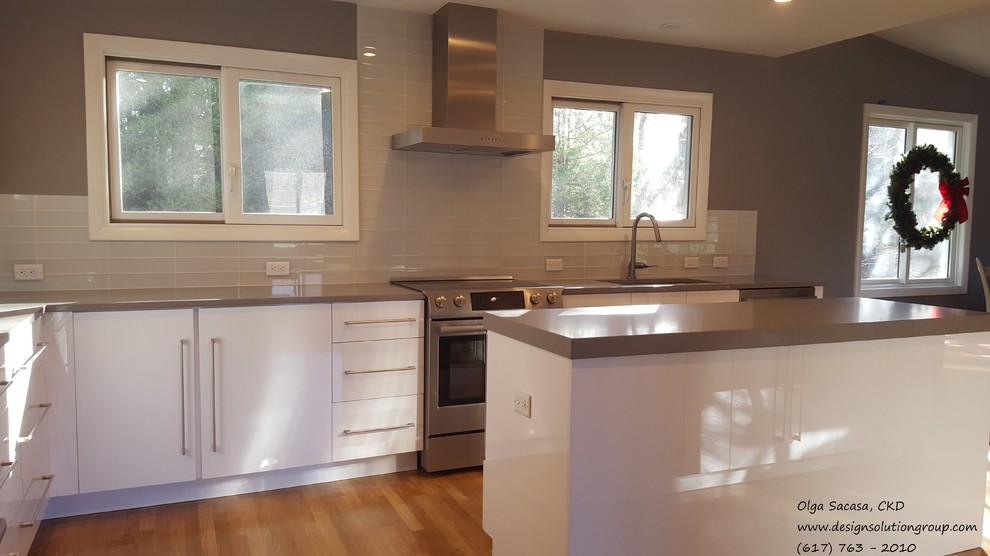 Example of a large trendy u-shaped medium tone wood floor kitchen design in Boston with flat-panel cabinets, white cabinets, quartz countertops, stainless steel appliances, an island, an undermount sink, white backsplash and glass tile backsplash