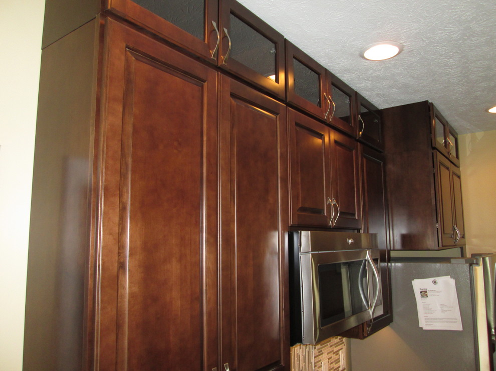 Inredning av ett modernt mellanstort kök, med en undermonterad diskho, luckor med upphöjd panel, skåp i mörkt trä, bänkskiva i kvarts, flerfärgad stänkskydd, stänkskydd i mosaik, rostfria vitvaror, klinkergolv i porslin och en halv köksö