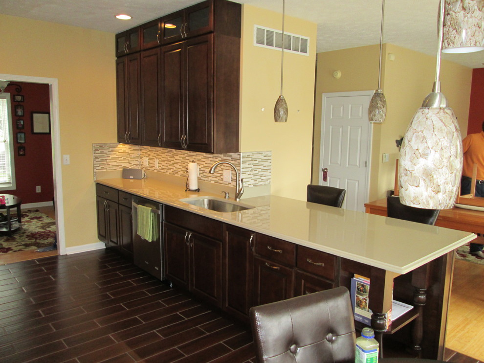 Exempel på ett mellanstort modernt kök, med en undermonterad diskho, luckor med upphöjd panel, skåp i mörkt trä, bänkskiva i kvarts, flerfärgad stänkskydd, stänkskydd i mosaik, rostfria vitvaror, klinkergolv i porslin och en halv köksö