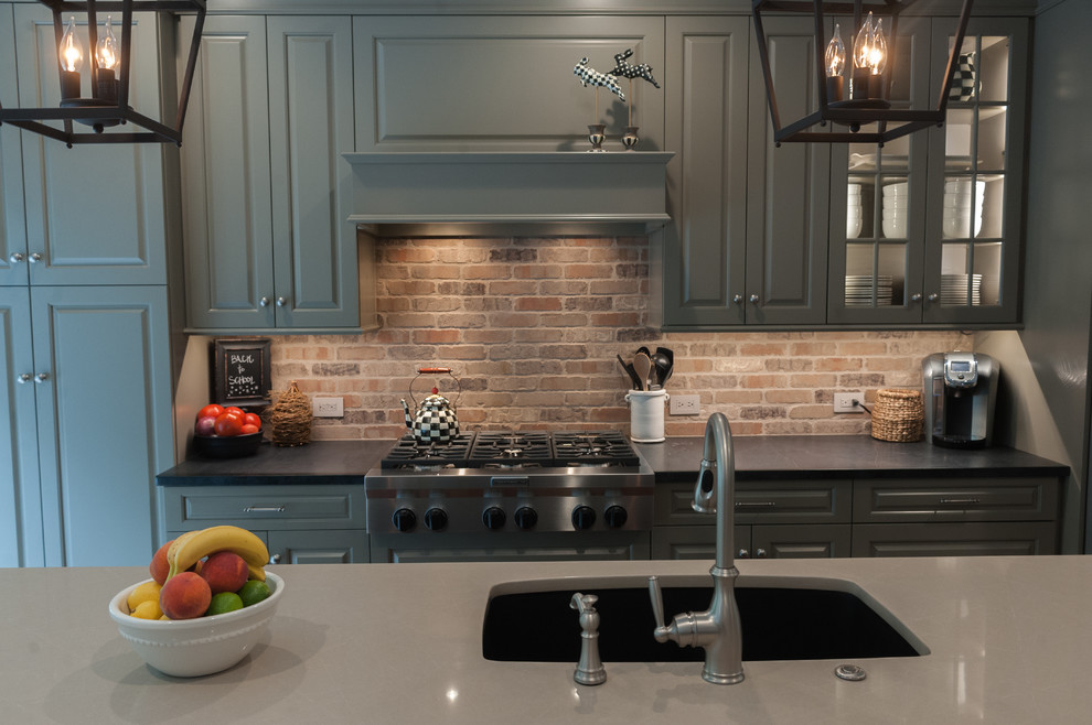 Inspiration for a kitchen remodel in Philadelphia with an undermount sink, raised-panel cabinets, green cabinets, soapstone countertops, brick backsplash, stainless steel appliances and an island