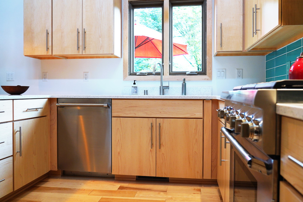 Immagine di una cucina abitabile minimalista di medie dimensioni con lavello da incasso, ante lisce, ante in legno scuro, top in quarzo composito, paraspruzzi blu, elettrodomestici in acciaio inossidabile, parquet chiaro, penisola e top bianco