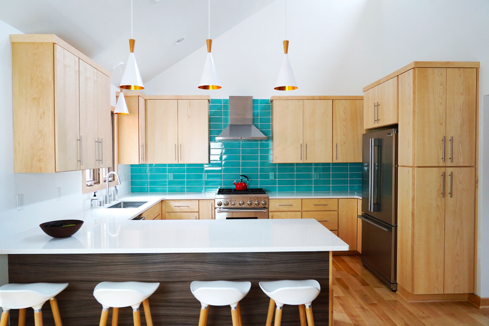 Inspiration for a medium sized midcentury kitchen/diner in Other with a built-in sink, flat-panel cabinets, medium wood cabinets, engineered stone countertops, blue splashback, stainless steel appliances, light hardwood flooring, a breakfast bar, white worktops and metro tiled splashback.