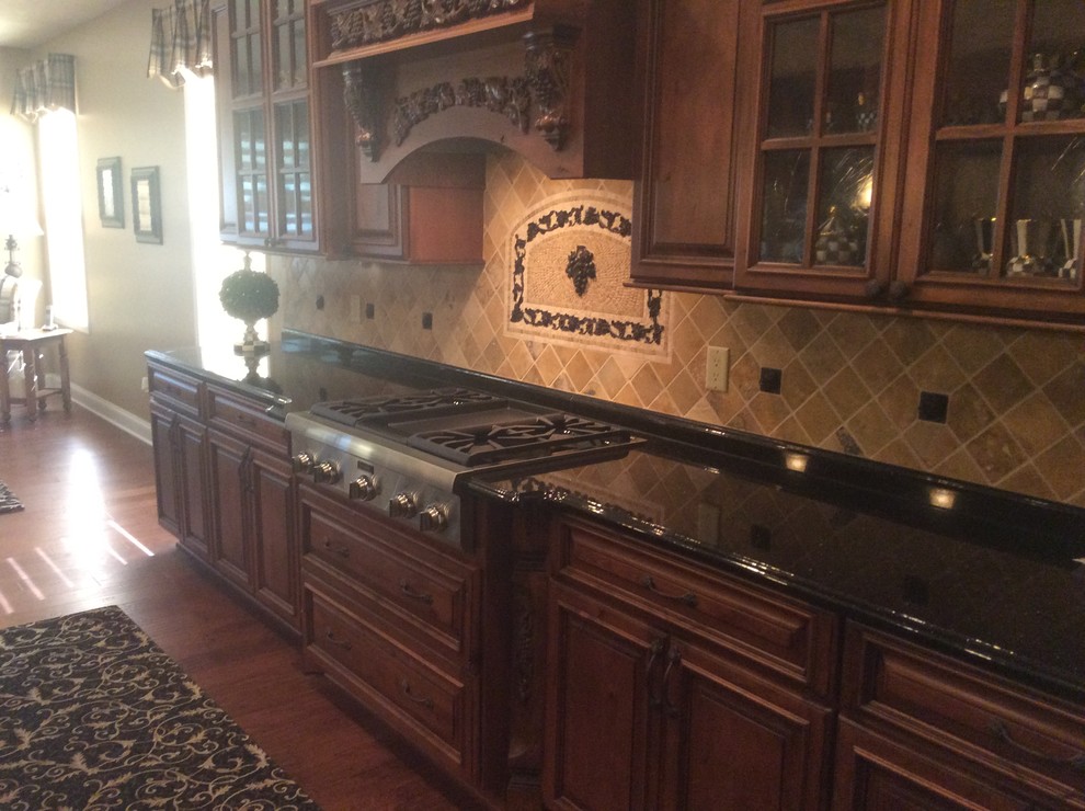 Mittelgroße Mediterrane Küche mit hellbraunen Holzschränken, Granit-Arbeitsplatte, bunter Rückwand und Kücheninsel in Cleveland