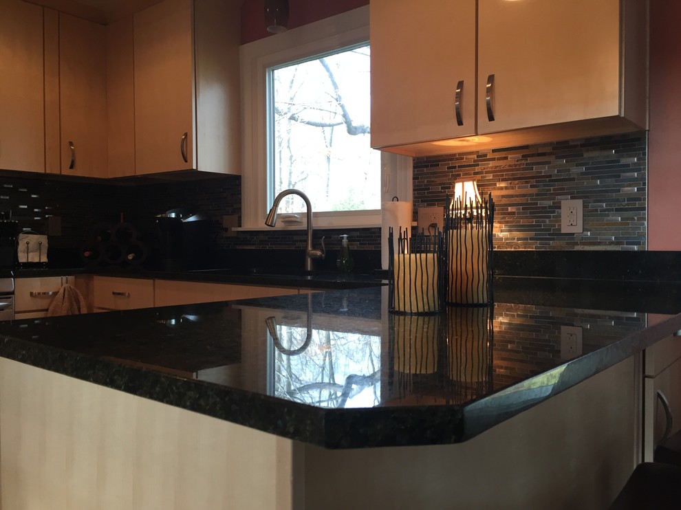 Example of a mid-sized classic u-shaped light wood floor kitchen design in Cleveland with an undermount sink, light wood cabinets, granite countertops, multicolored backsplash, glass sheet backsplash, stainless steel appliances and a peninsula