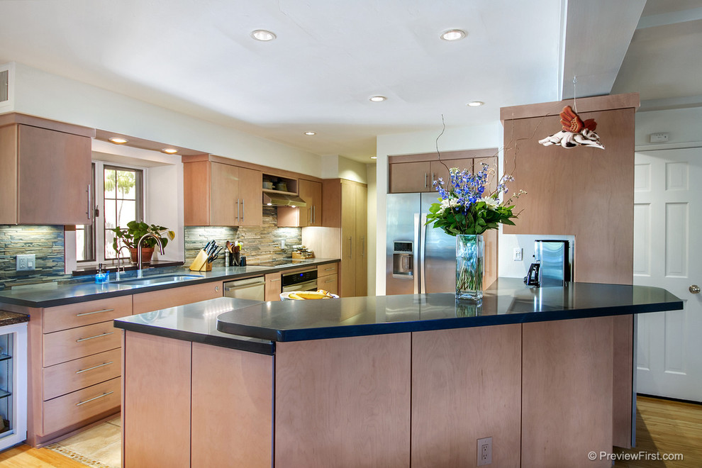 Eat-in kitchen - mid-sized contemporary galley light wood floor eat-in kitchen idea in San Diego with an undermount sink, flat-panel cabinets, light wood cabinets, quartz countertops, multicolored backsplash, matchstick tile backsplash, stainless steel appliances and a peninsula